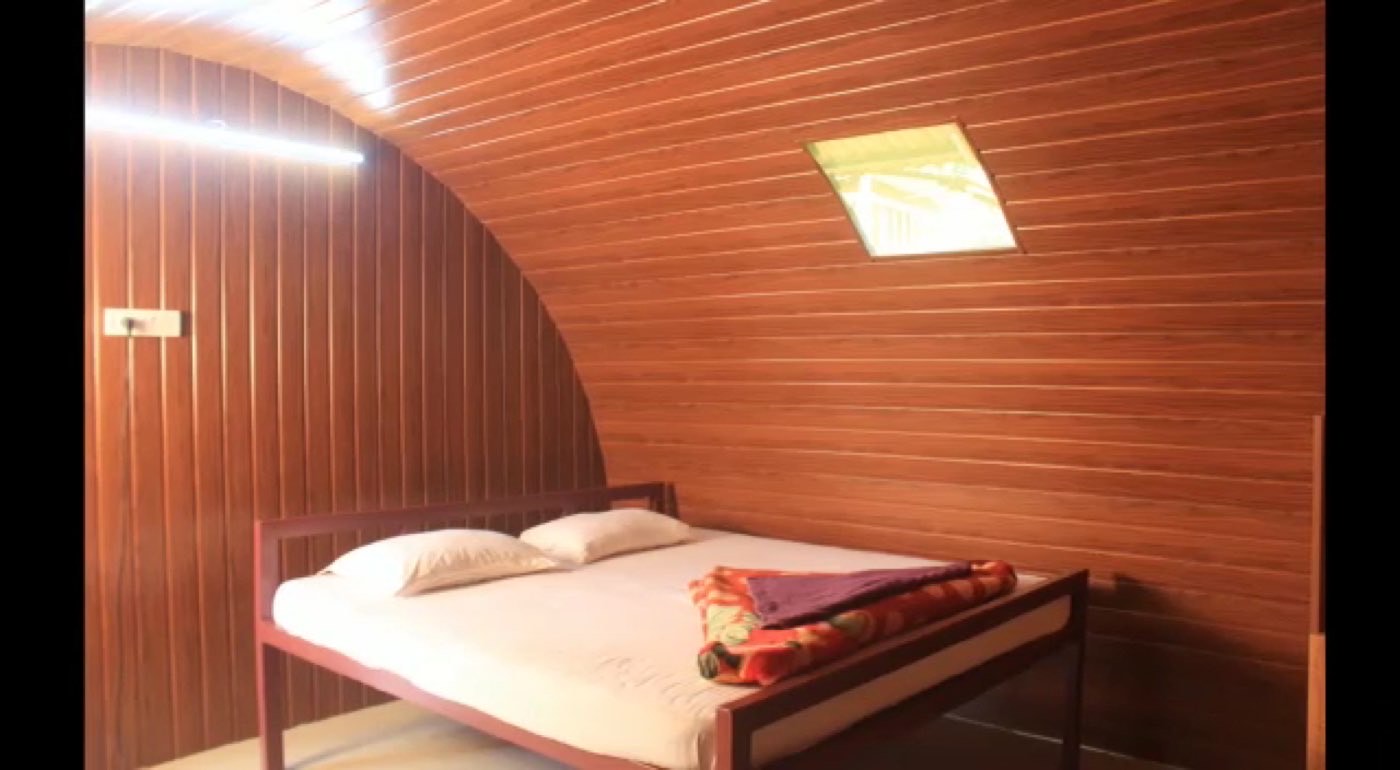 Wooden Cottage room with a curved wooden ceiling and skylight